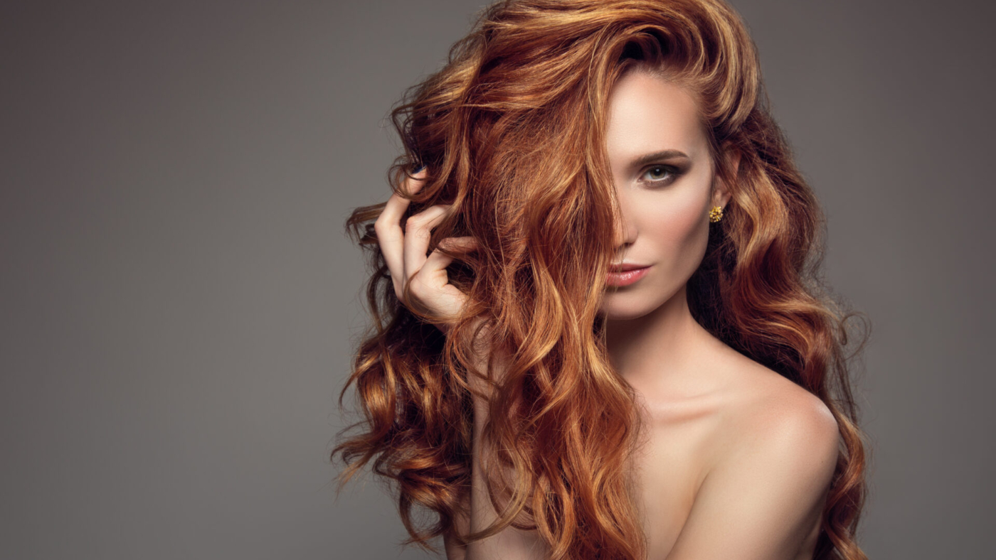 Portrait of woman with long curly beautiful ginger hair.