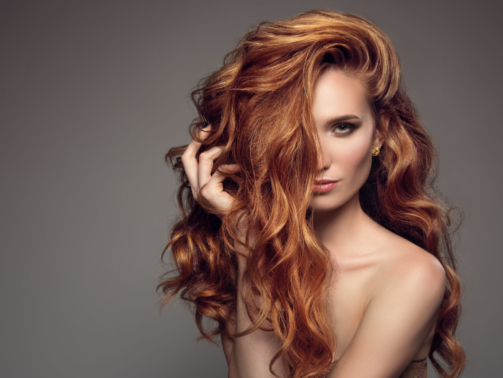 Portrait of woman with long curly beautiful ginger hair.